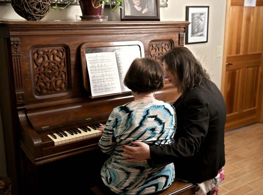 A caregiver and resident at the piano